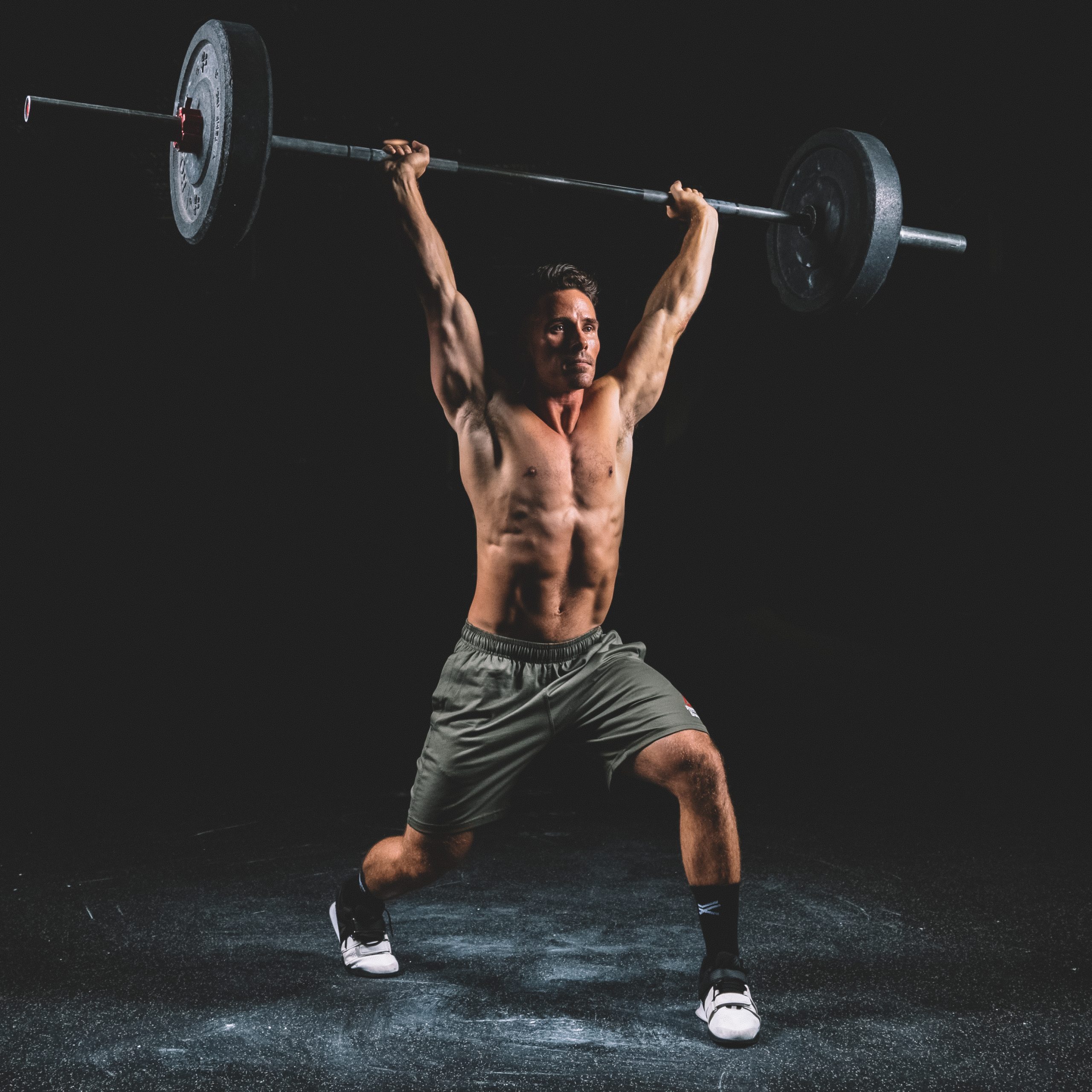 Homme musclé qui fait de l'haltérophilie, du sport